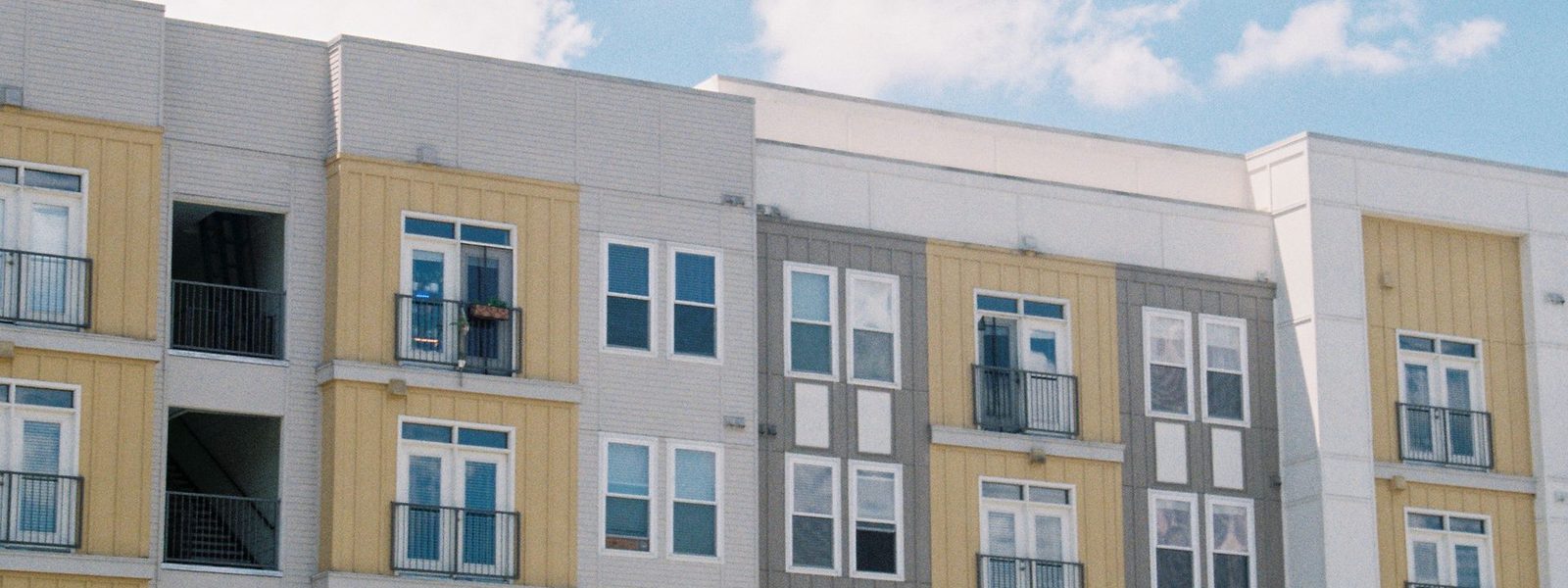 A modern mid-rise apartment block against a clear sky