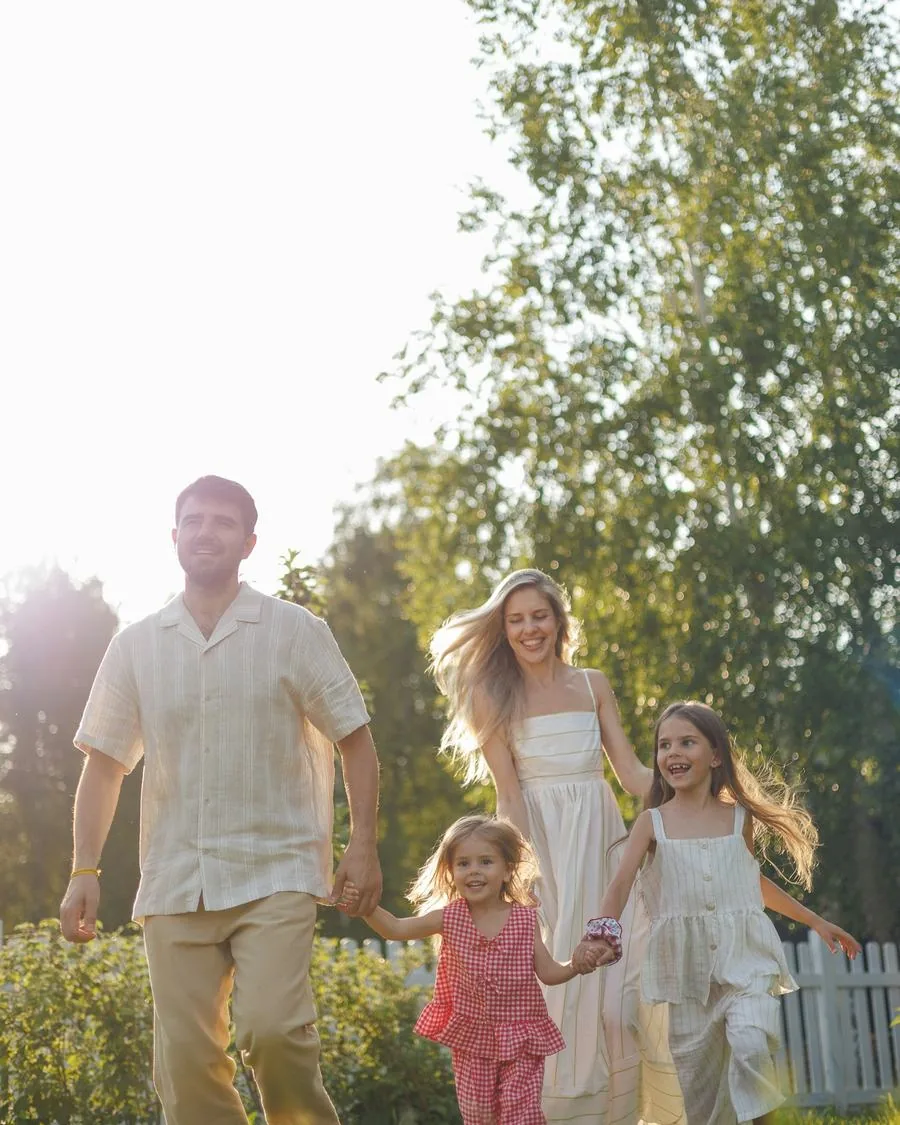 A family walking forward together through a sunlit garden