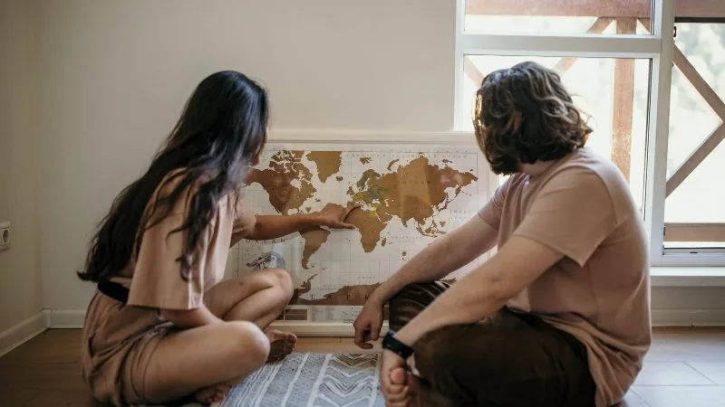 A couple studying a world map together