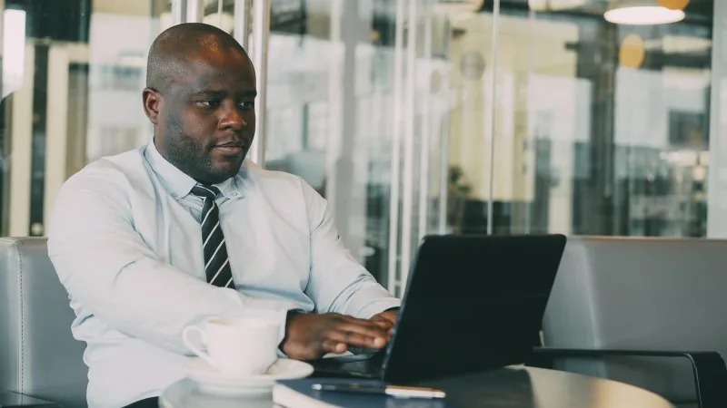 A business owner working at a laptop in a bright office